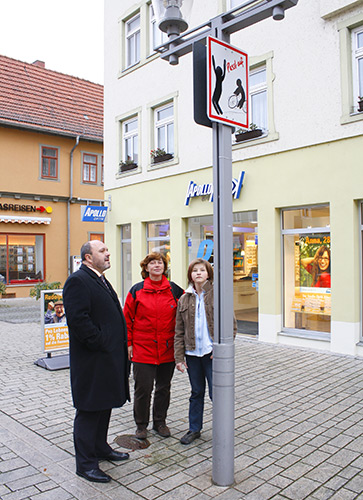 Bürgermeister Jörg Reichl (BfR), Lehrerin Birgit Helbig und Schülerin Bianca Günther bei der Übergabe eines der Hinweisschilder.