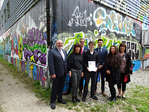 Victor Gluschkov (4. v. l.) als Preisträger und Michael Grisko (3.v.l.) als Überreicher mit Gratulanten vor der neugestalteten Graffiti-Fassade der saalgärten. Foto: Frank Michael Wagner