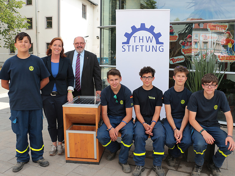 Dr. Cornelia Lawrenz, Geschäftsführerin der THW-Stiftung und Bürgermeister Jörg Reichl zusammen mit den Unterstützern des THW an der neuen Sitzbank. Foto: Alexander Stemplewitz