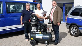 Ortsbeauftragter des THW Falk Lehmann, Geschäftsführer Andreas Eska und Bürgermeister Jörg Reichl (v.l.n.r.) bei der Übergabe des Kompressors auf dem Gelände des THW