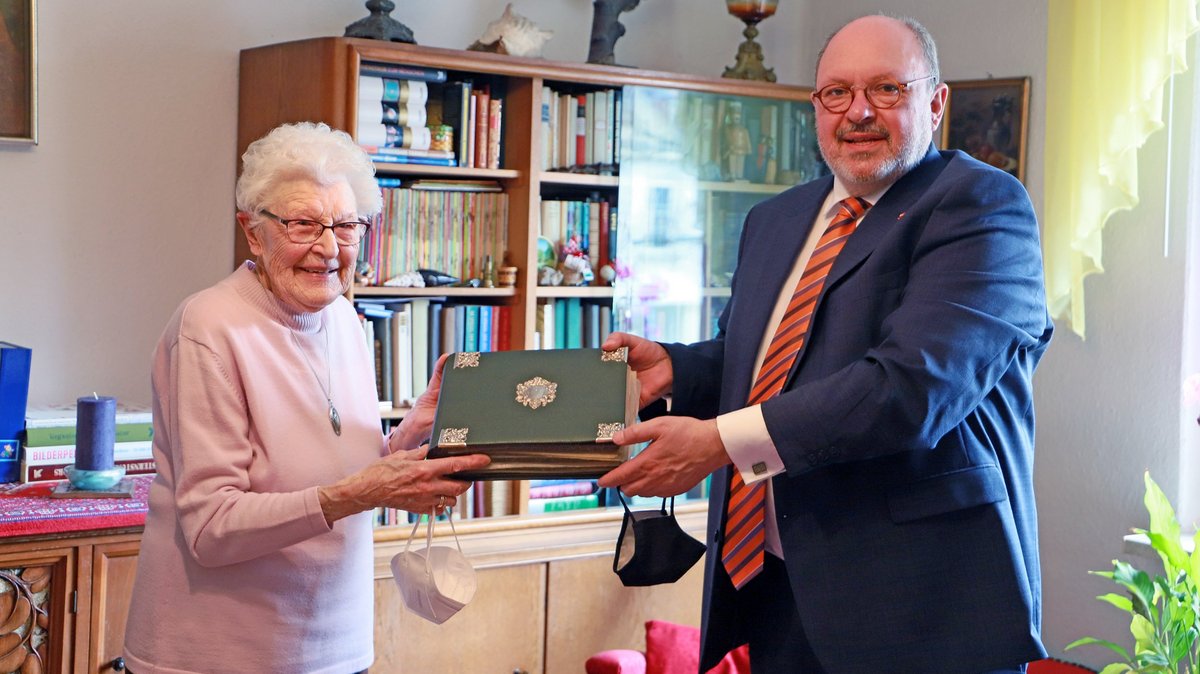 Ursula Liebold übergibt ein Fotoalbum der Mitglieder der Altstädter Vereinigung an Bürgermeister Jörg Reichl für das Stadtarchiv Rudolstadt.