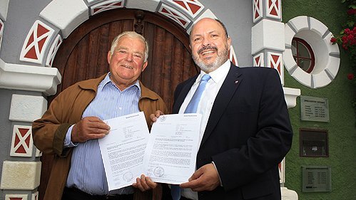 Foto: Bürgermeister Jörg Reichl und Conrad Bretschneider beim Austausch der Vereinbarungen zur Fahrzeugbeschaffung