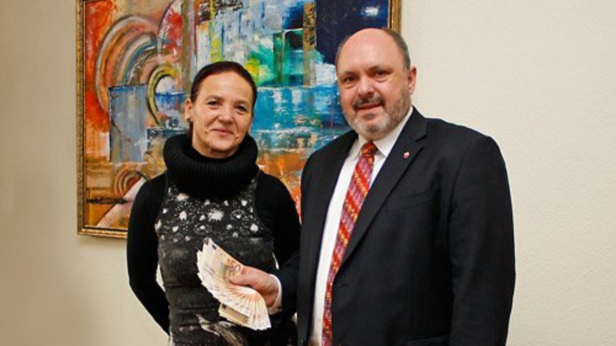 Bürgermeister Jörg Reichl überreicht der Geschäftsführerin Karin Arnold vom Thüringer Folklore Tanzensemble Rudolstadt e.V. die Spende in Höhe von 1000 Euro