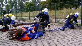 Foto: Ein Suchtrupp bei der Suche einer Person, im Hintergrund steht bereits ein Rettungstrupp bereit. 