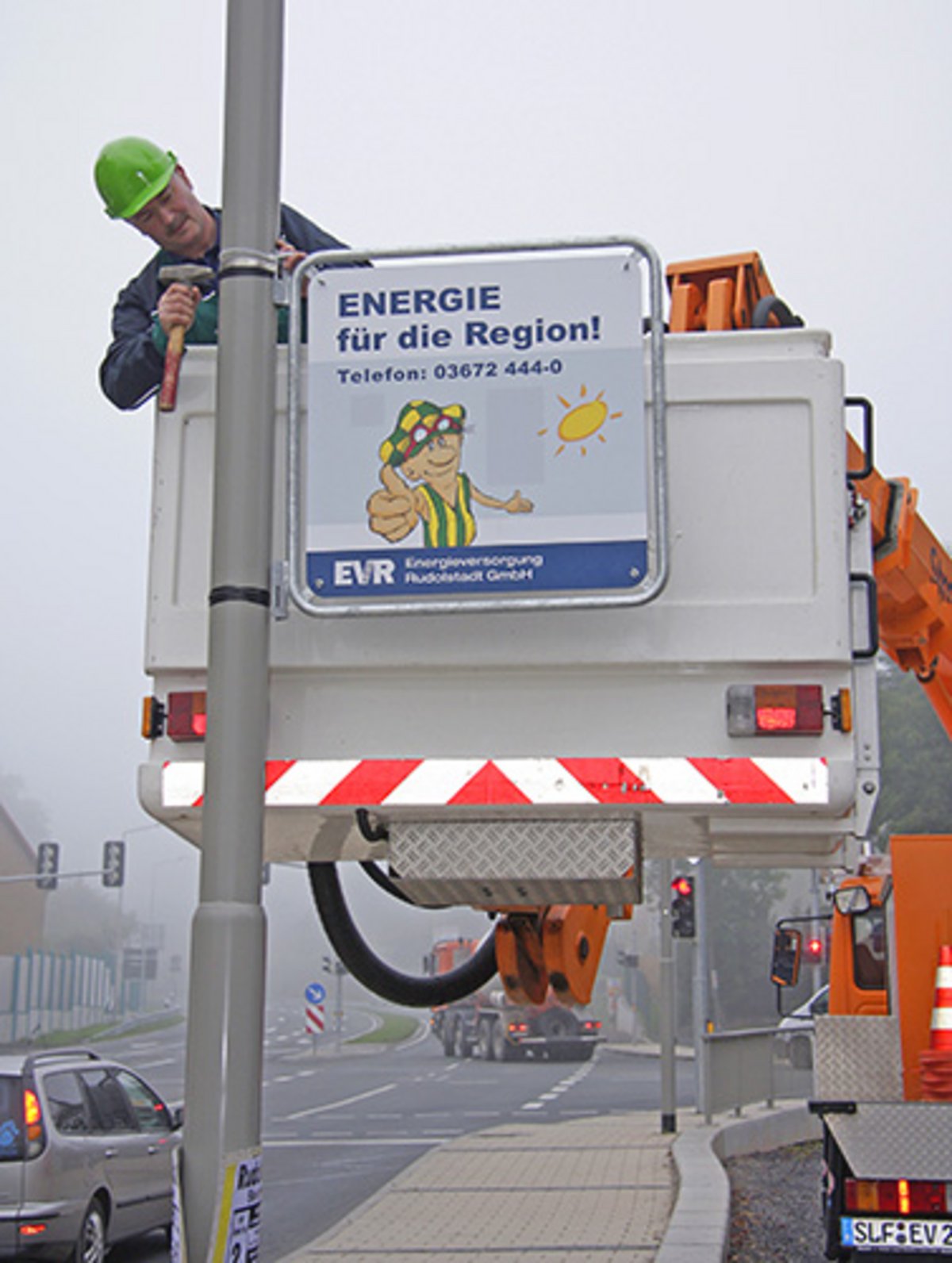 EVR-Mitarbeiter Rolf Sonnabend  installiert in der Nähe der  Ankerwerkskreuzung,  Richtung stadtauswärts ein Werbeschild in der neuen, zukünftig für alle verbindlichen Ausführung. Das Schild soll als Beispiel und Anschauungsobjekt für Gewerbetreibende dienen, die weiterhin Interesse an Hinweisen und Werbung an Lampenmasten in Rudolstadt haben. 