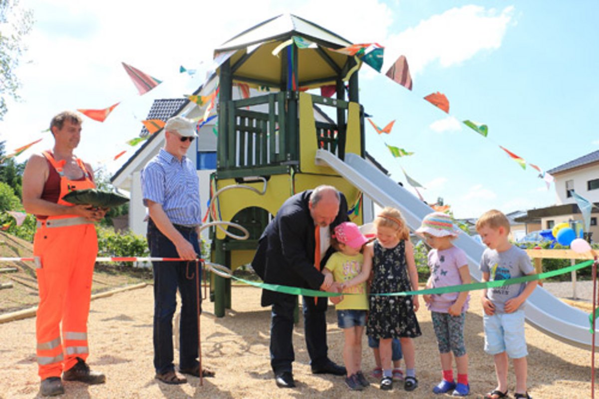 Michael Sommer, Mitarbeiter des städtischen Bauhofes, Lothar Schilling von der Strabag AG Rudolstadt, Bürgermeister Jörg Reichl und Kinder des Wohngebietes eröffnen gemeinsam zum Kindertag den neuen Spielplatz. Foto: Alexander Stemplewitz