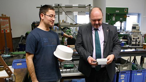 Bild: Henning Marter (links) der Firma Funkbau Henning Marter erläutert Bürgermeister Jörg Reichl eines der am Standort entwickelten Produkte mit Funktechnik