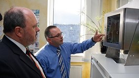 Bild: Bürgermeister Jörg Reichl lässt sich von Geschäftsführer Dr. Steffen Biehl die Funktionsweise eines der Systeme zur Schadensfrüherkennung erklären.