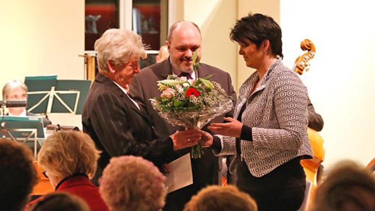 Foto: Nicole Eckert der Aeltesten Volkstedter Porzellanmanufaktur (rechts im Bild) gratuliert zusammen mit Bürgermeister Jörg Reichl der Ortsteilbürgermeisterin Edeltraud Deutsch zu Beginn des Weihnachtskonzertes