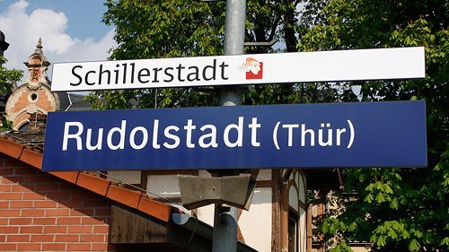 Zusätzlicher Hinweis "Schillerstadt" an einem Stationsschild des Rudolstädter Bahnhofs