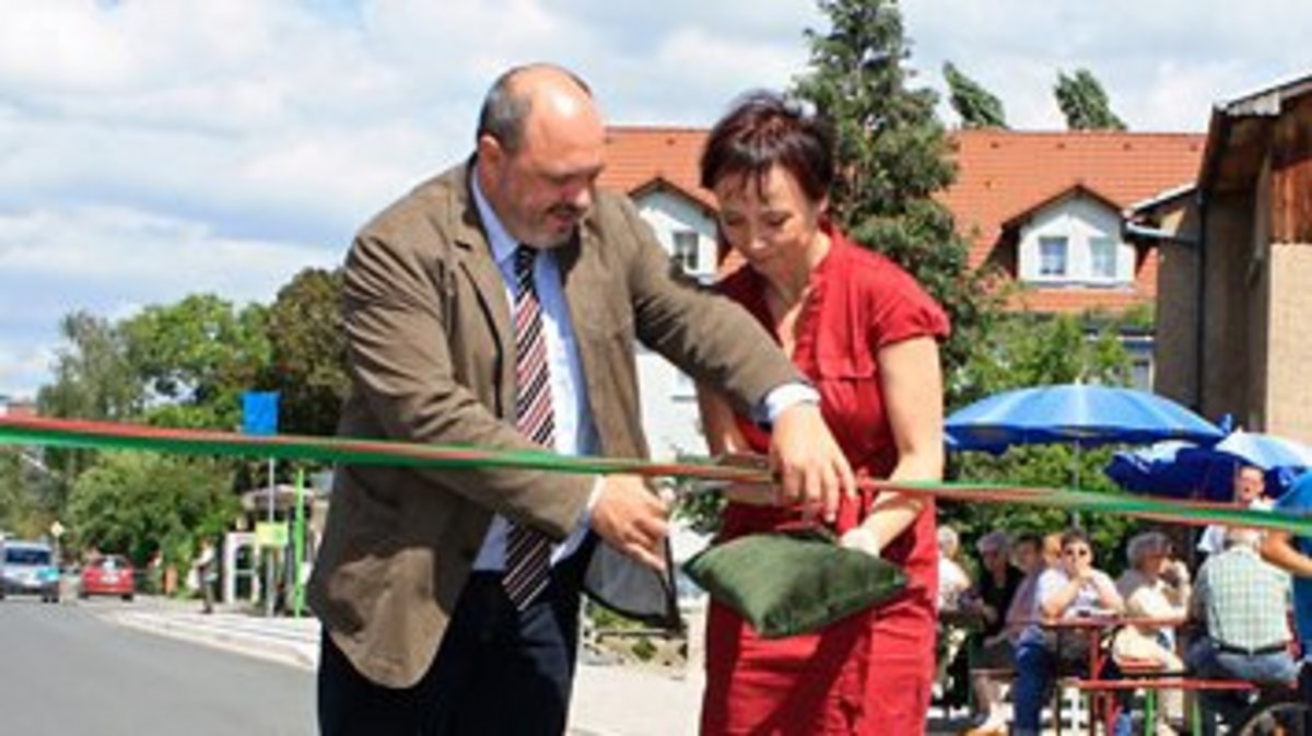 Bild: Rudolstadts Bürgermeister Jörg Reichl und Ortssprecherin Elke Träuptmann durchschneiden das Band bei der Straßenübergabe