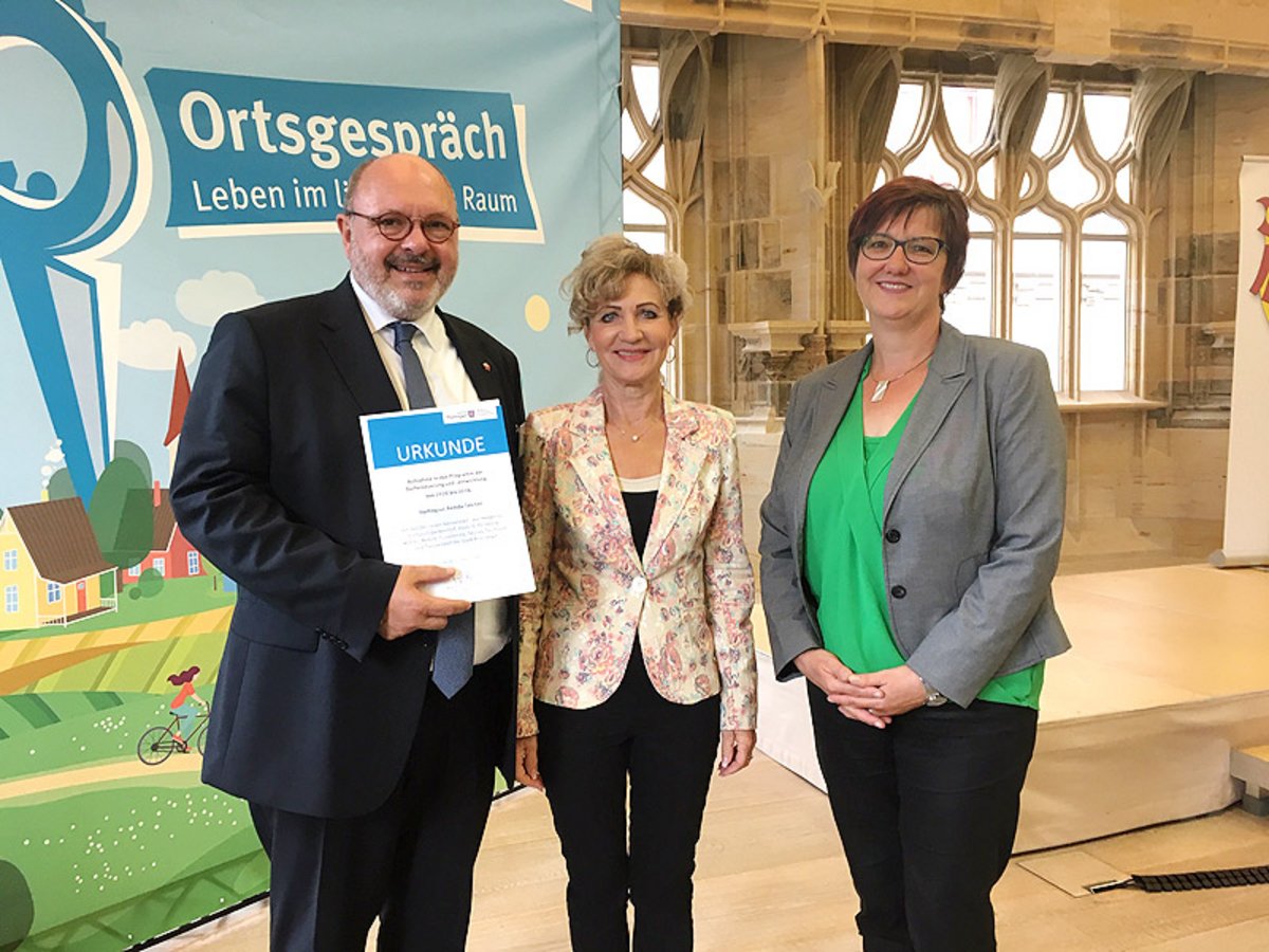 Ministerin Birgit Keller (Bildmitte) bei der Urkundenübergabe für Remda-Teichel an Bürgermeister Jörg Reichl und Stadtmitarbeiterin Petra Ihm. Foto: TMIL